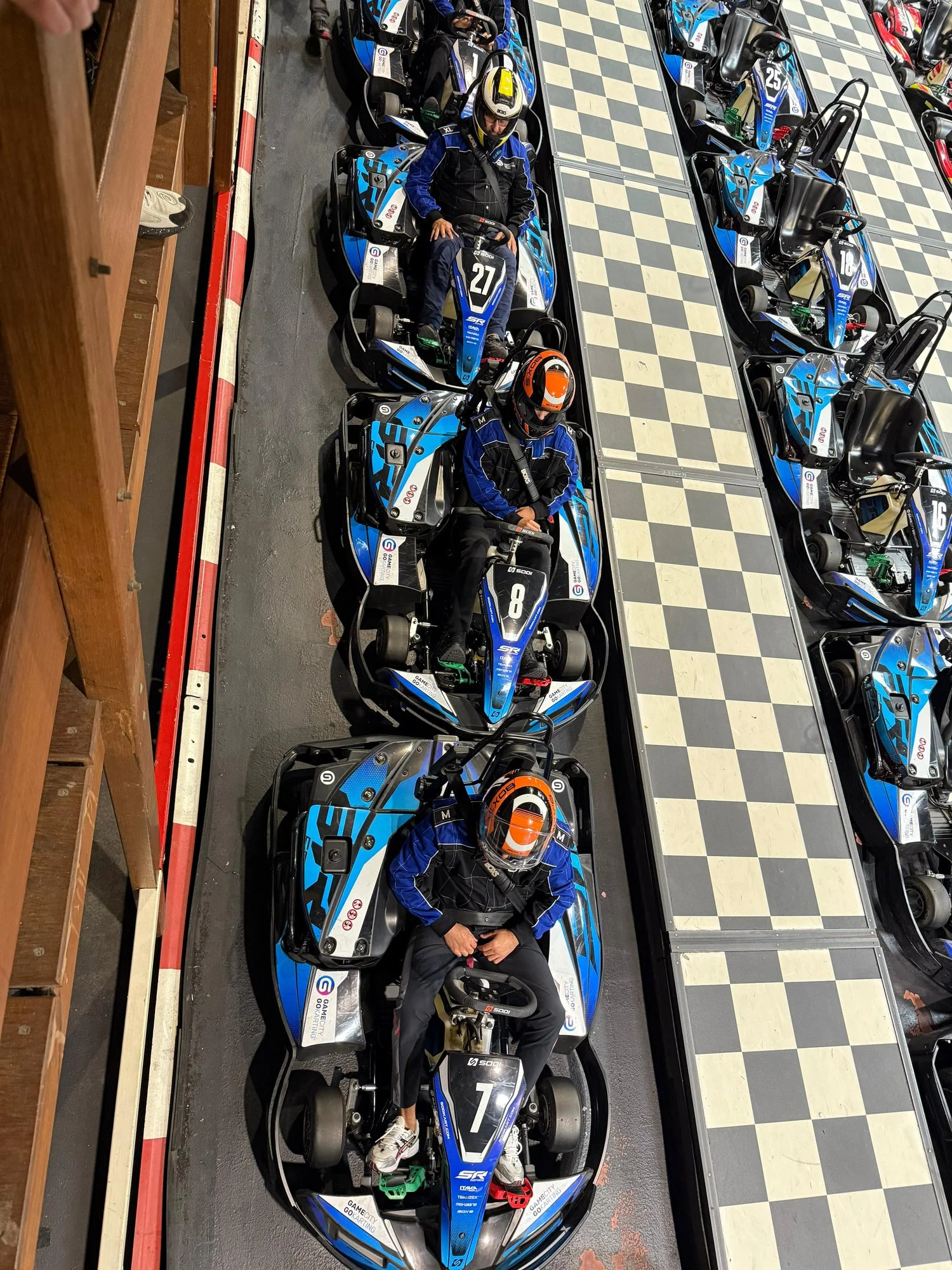 Jongeren van Cara Care in karts op de baan, van bovenaf gezien