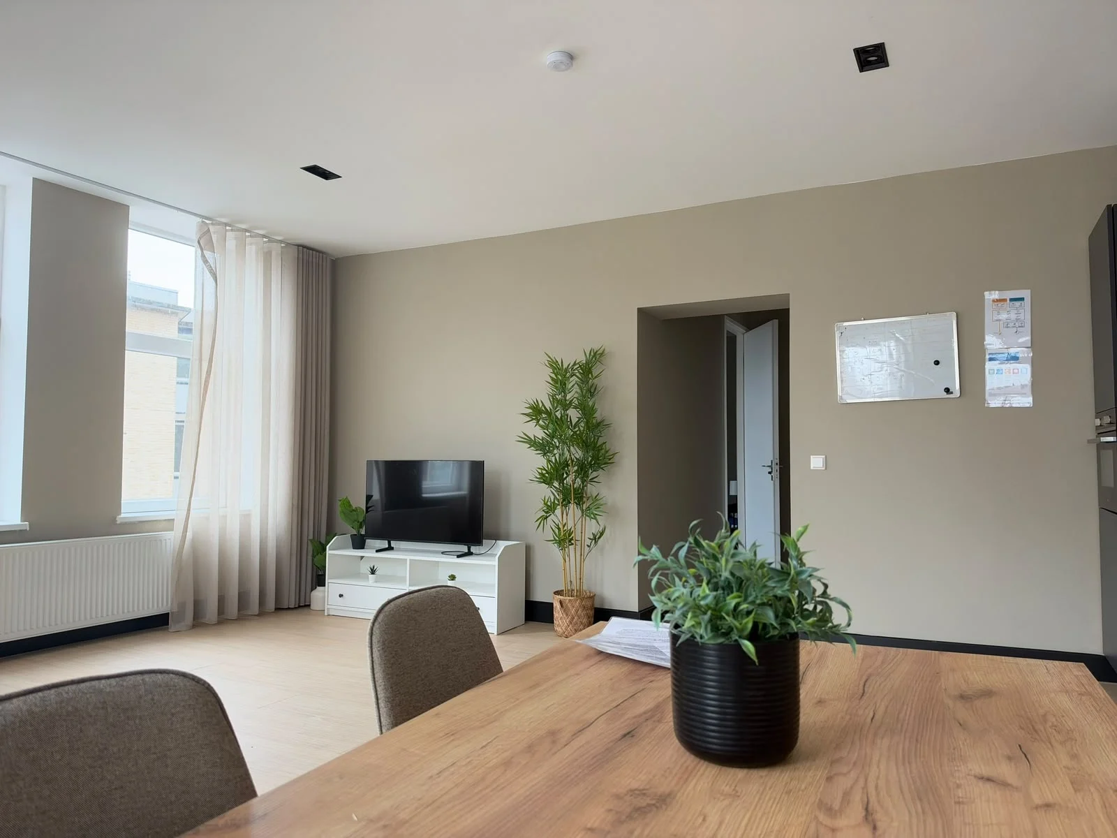 Lichte woonkamer met een planbord in een van de woonvoorzieningen van Cara Care