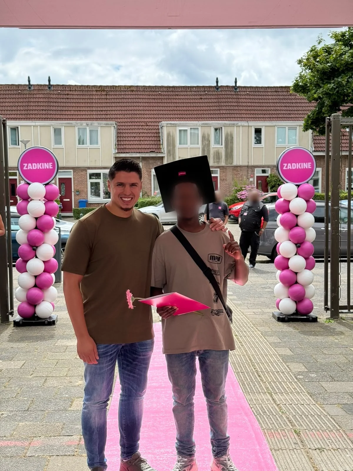 Een jongere van Cara Care met zijn diploma en afstudeerhoed bij de diploma-uitreiking