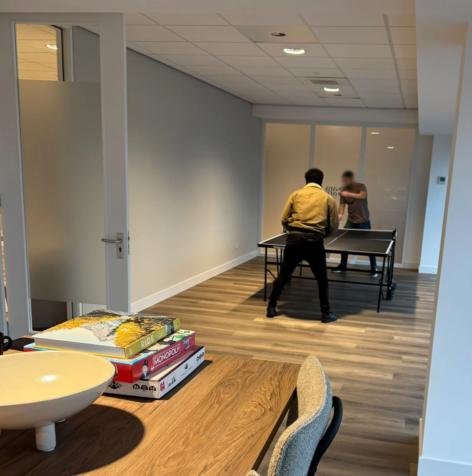 Twee mensen spelen tafeltennis op het kantoor van Cara Care